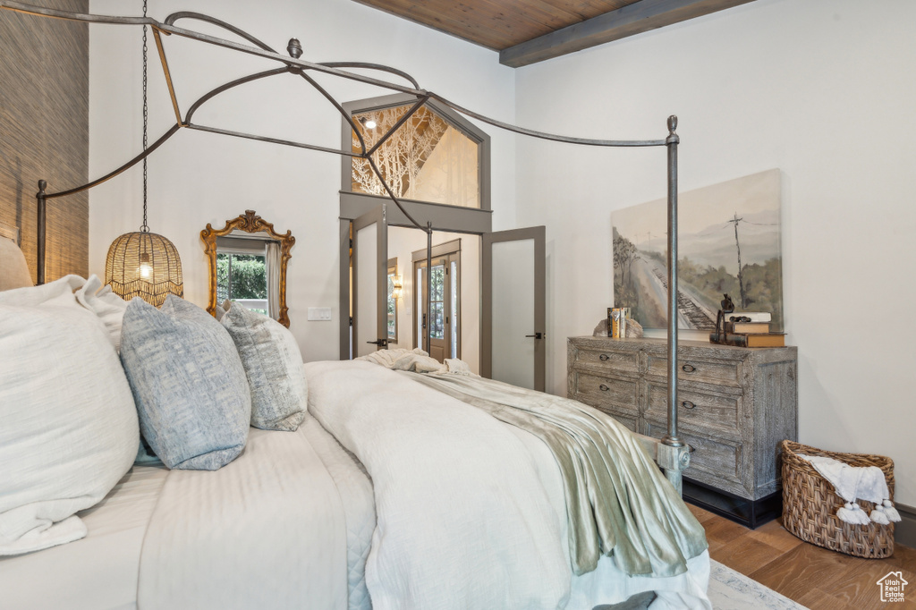 Bedroom featuring wooden ceiling, wood finished floors, and a towering ceiling
