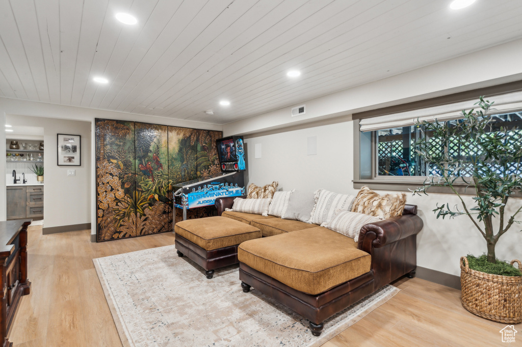 Living area with light wood finished floors, recessed lighting, wood ceiling, and bar