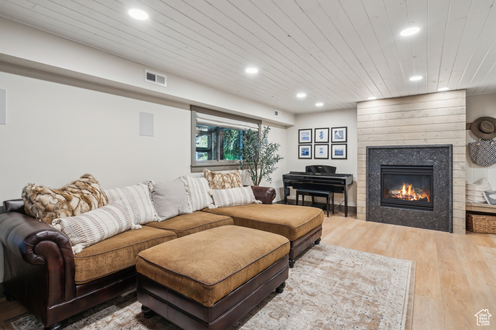 Living area with wood finished floors, recessed lighting, wood ceiling, and a tile fireplace
