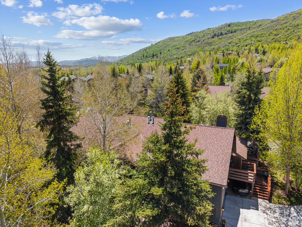 View from above of property with a mountain backdrop and a forest
