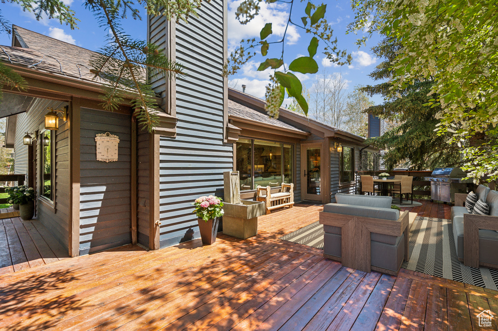 Deck with an outdoor living space, outdoor dining space, and grilling area