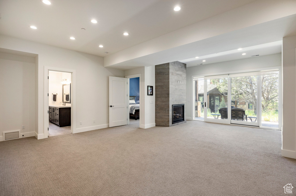 Unfurnished living room with light carpet, recessed lighting, baseboards, and a fireplace