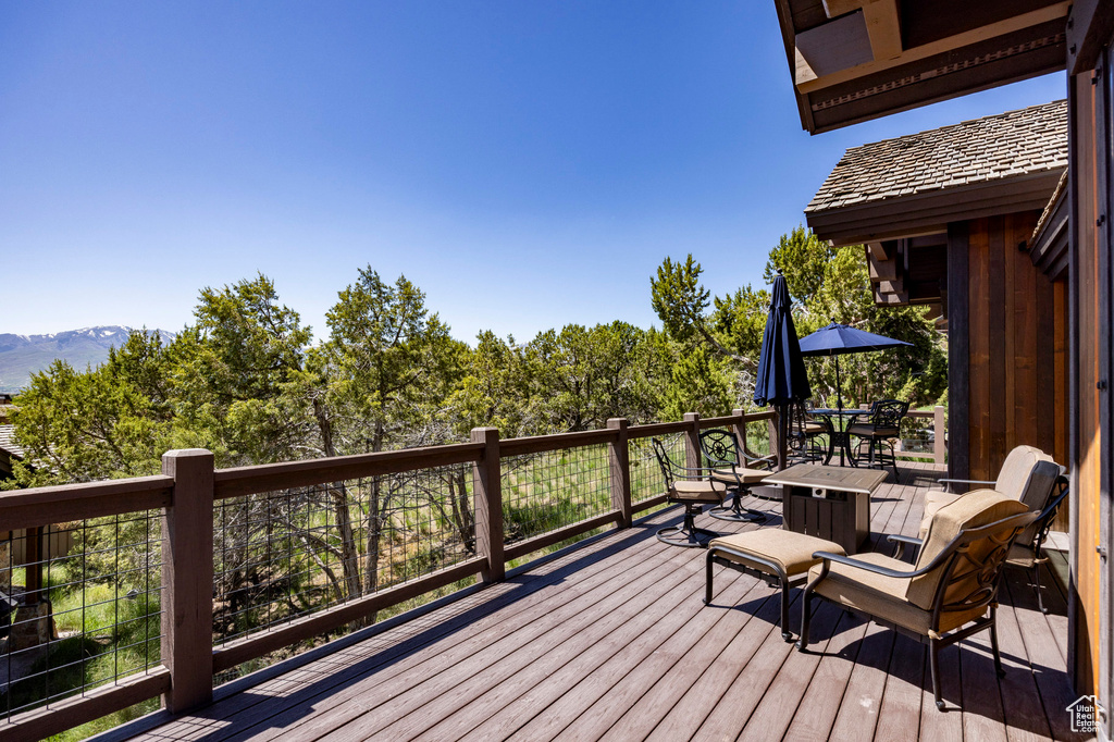 Wooden deck with outdoor dining area and a mountain view