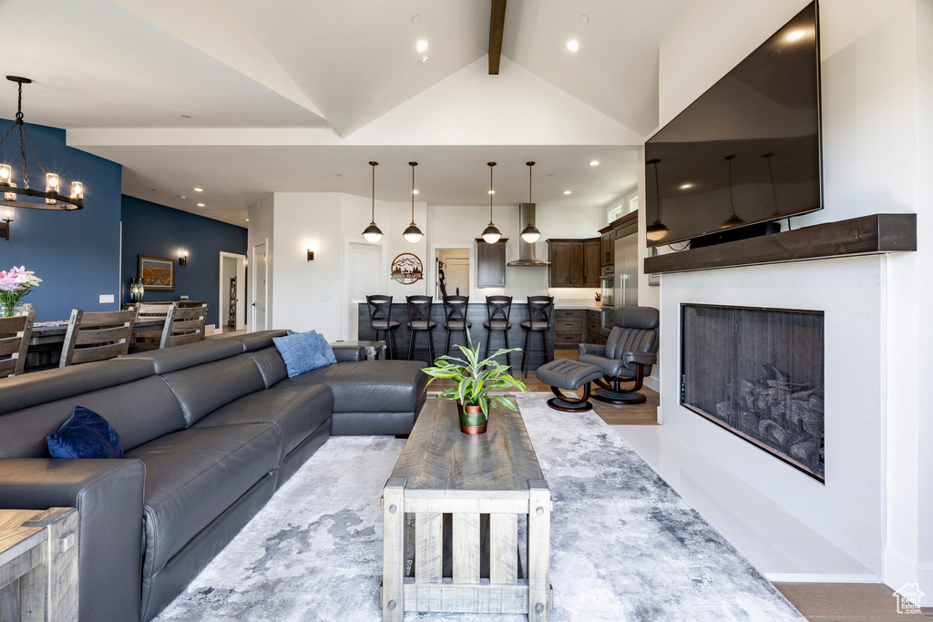Living area with a chandelier, recessed lighting, a fireplace, and wood finished floors