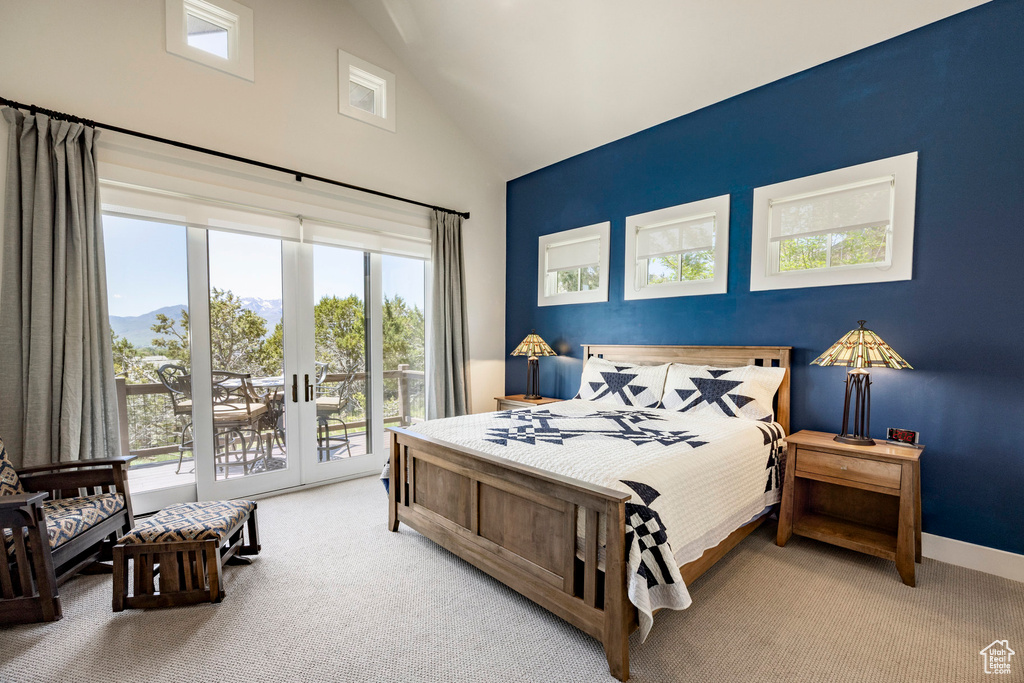 Bedroom with high vaulted ceiling, access to exterior, light carpet, french doors, and a mountain view