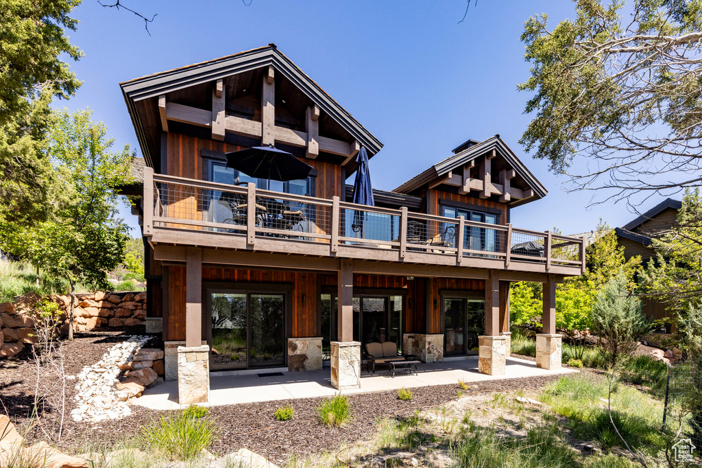 Rear view of house with a patio area, a deck, and board and batten siding
