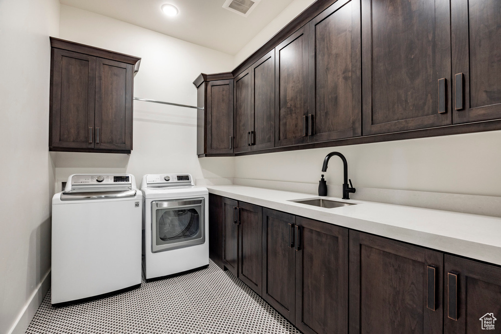 Laundry area with cabinet space, separate washer and dryer, recessed lighting, and baseboards