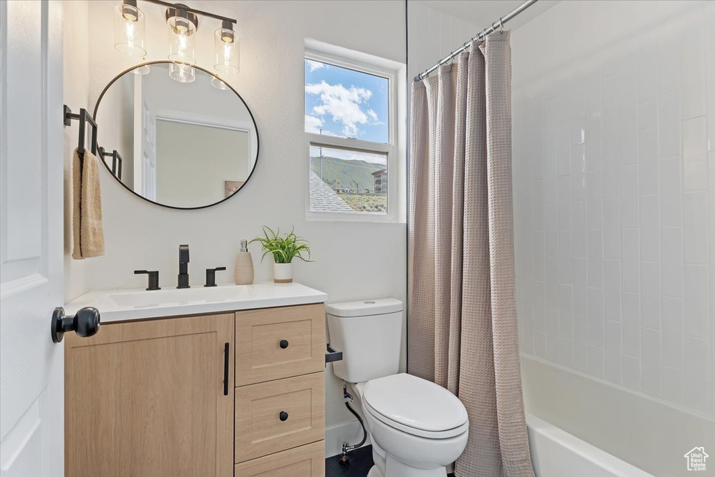 Full bath with toilet, vanity, and shower / bath combo