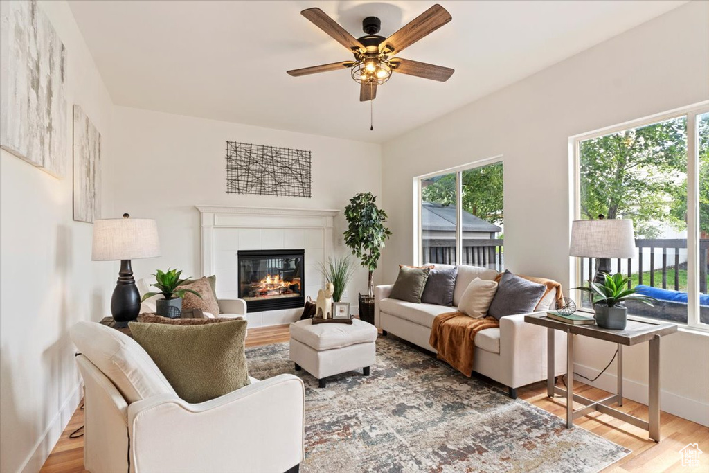 Living area with plenty of natural light, light wood-type flooring, and ceiling fan