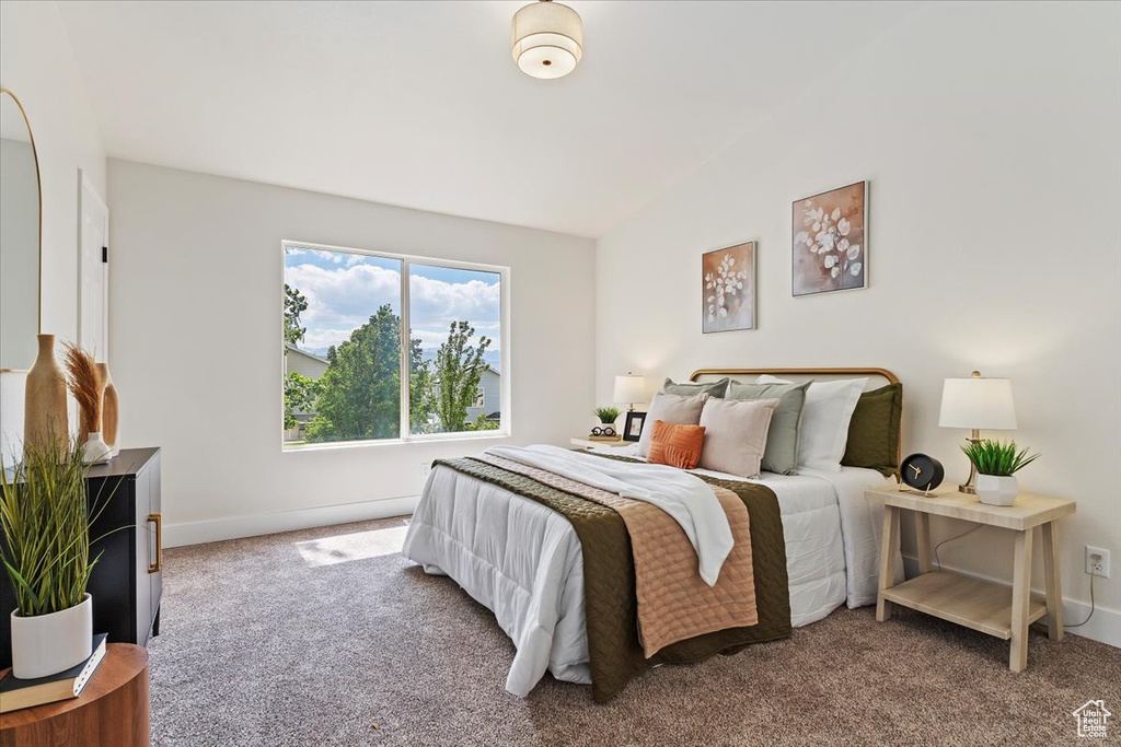 Bedroom featuring carpet floors, lofted ceiling, and baseboards