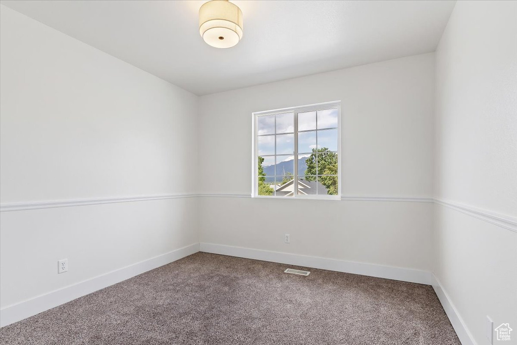 Carpeted spare room with baseboards