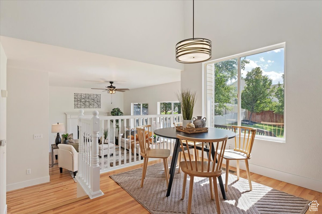Dining space featuring healthy amount of natural light, light wood finished floors, baseboards, and a ceiling fan
