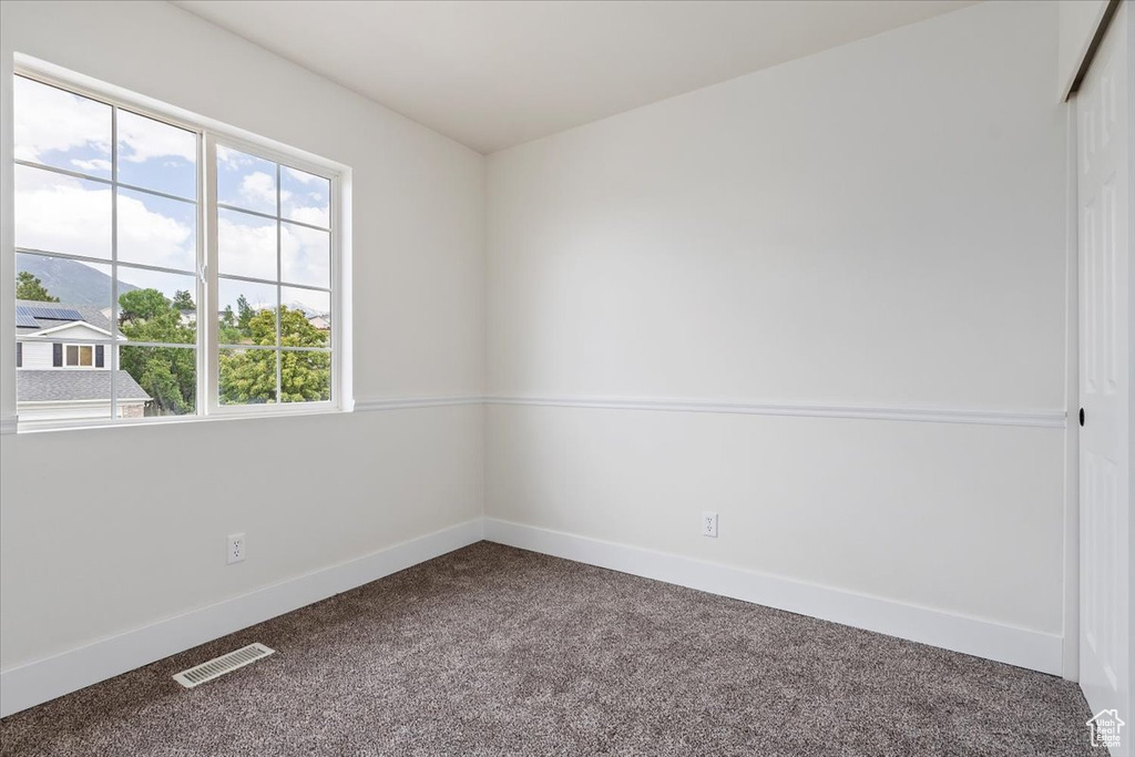 Carpeted empty room with baseboards