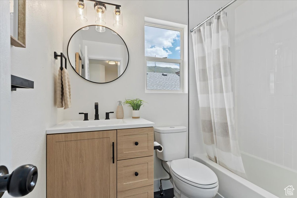 Bathroom with toilet, vanity, and shower / tub combo with curtain