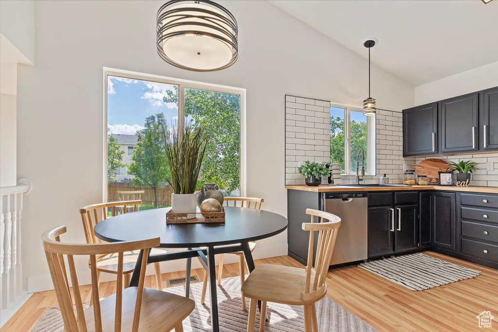 Dining room with light wood finished floors and high vaulted ceiling