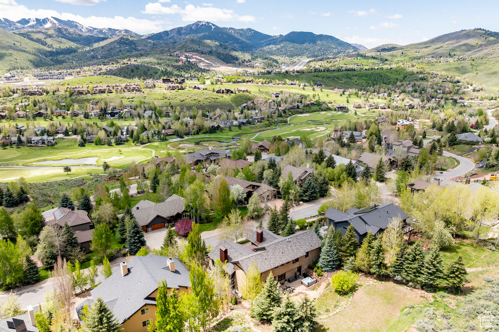 Aerial overview of property's location featuring mountains, nearby suburban area, and a golf course