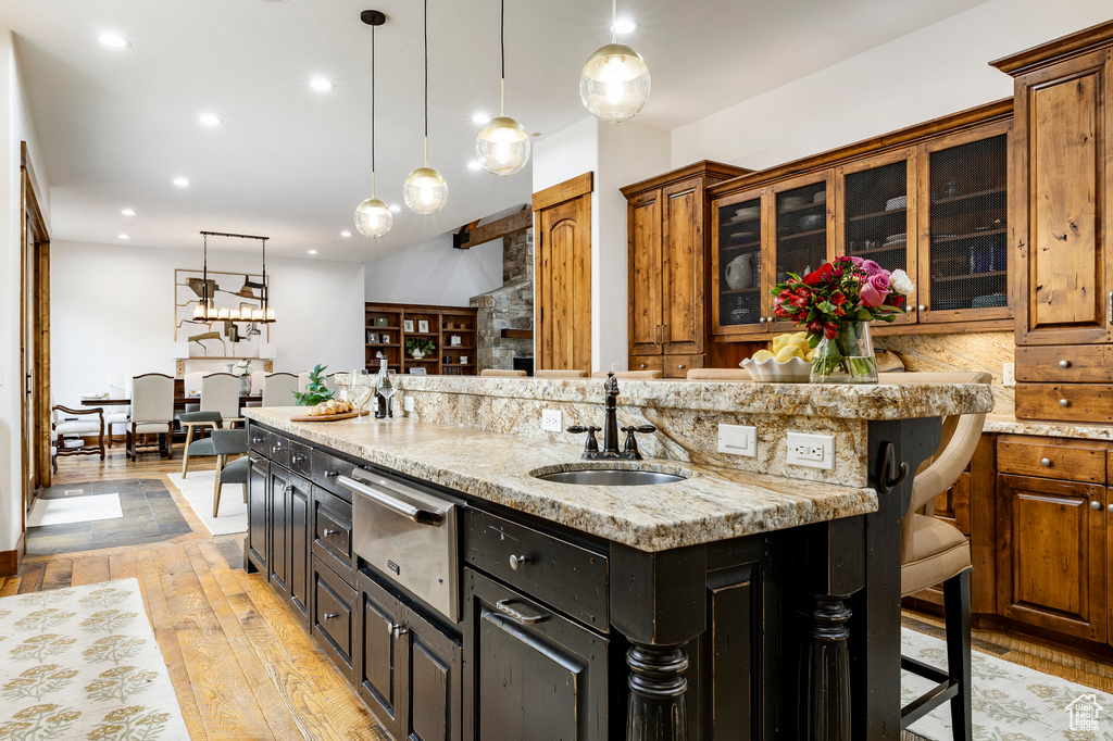 Kitchen with a warming drawer, a sink, a kitchen island with sink, a kitchen breakfast bar, and recessed lighting