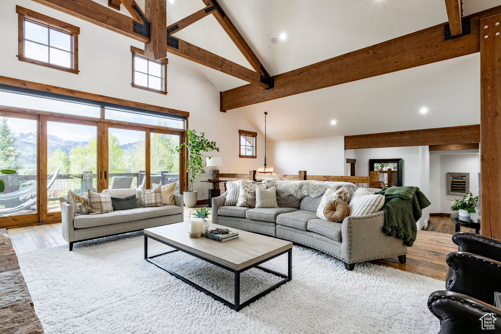 Living room featuring high vaulted ceiling, beam ceiling, hardwood / wood-style floors, recessed lighting, and a mountain view