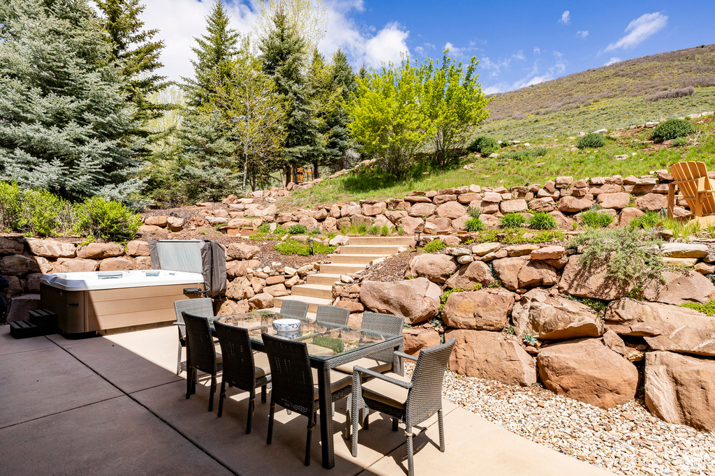 View of patio / terrace featuring outdoor dining space, stairway, and a mountain view