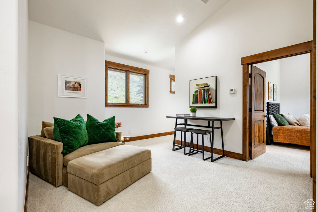 Living area with carpet flooring, lofted ceiling, baseboards, and recessed lighting