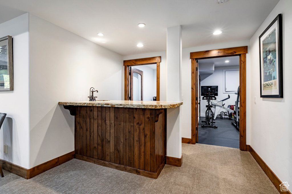 Bar area with baseboards, carpet flooring, recessed lighting, and a sink