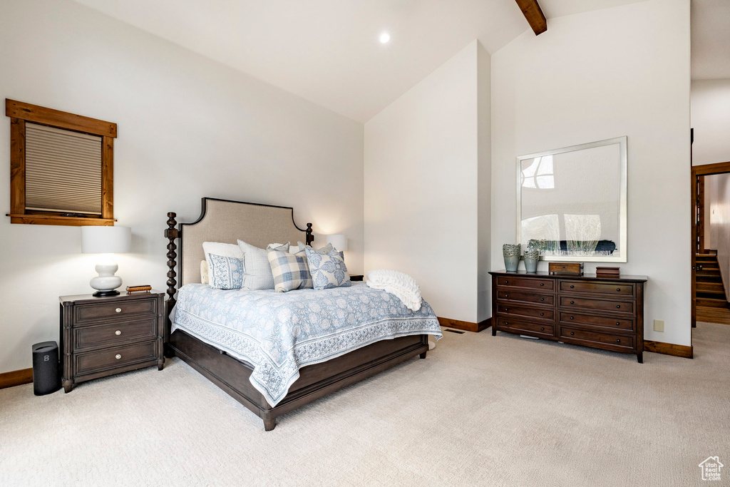 Bedroom with carpet flooring, baseboards, high vaulted ceiling, and beam ceiling