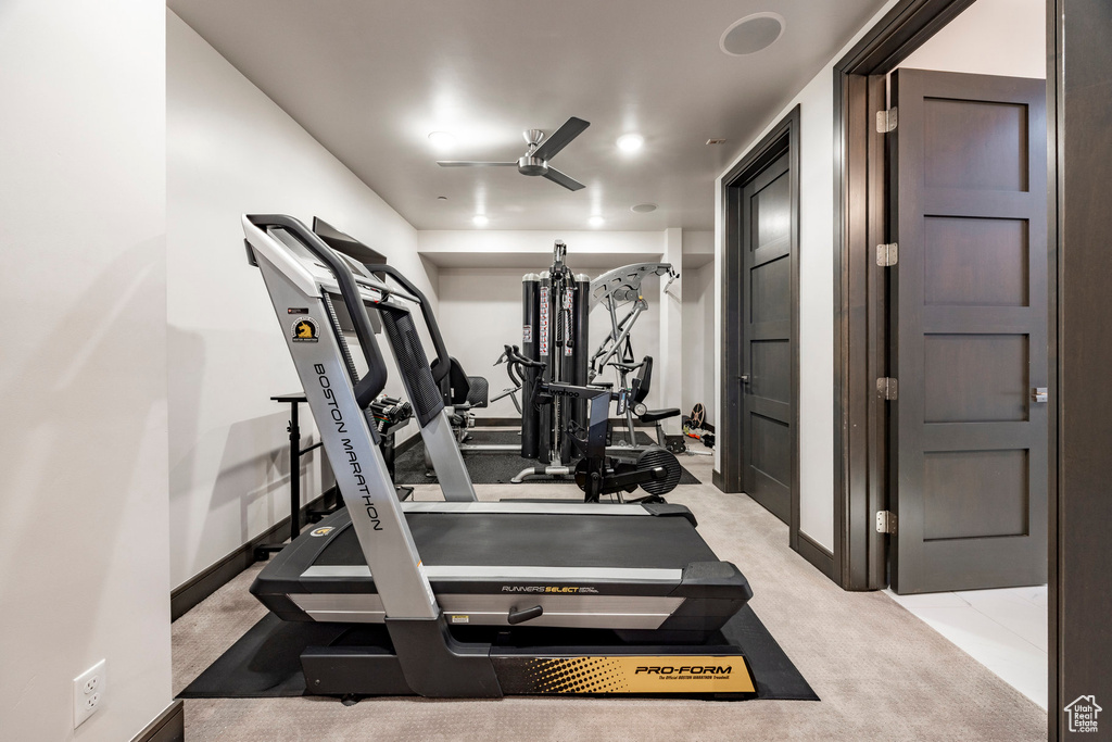Exercise room with a ceiling fan and baseboards