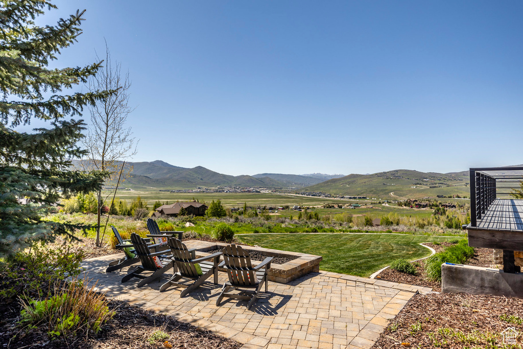 View of patio with a mountain view, a fire pit, and a rural view