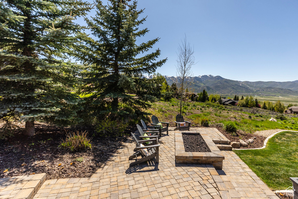 View of patio with a mountain view and a fire pit