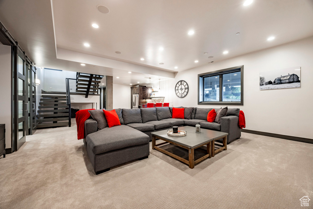 Living room with stairway, light carpet, recessed lighting, and baseboards