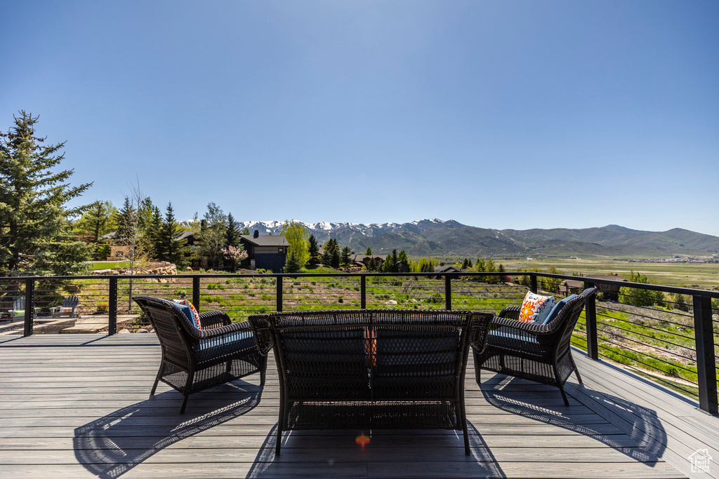 Wooden terrace featuring a mountain view and an outdoor hangout area