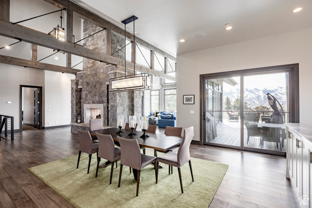 Dining area with high vaulted ceiling, wood finished floors, a chandelier, baseboards, and recessed lighting
