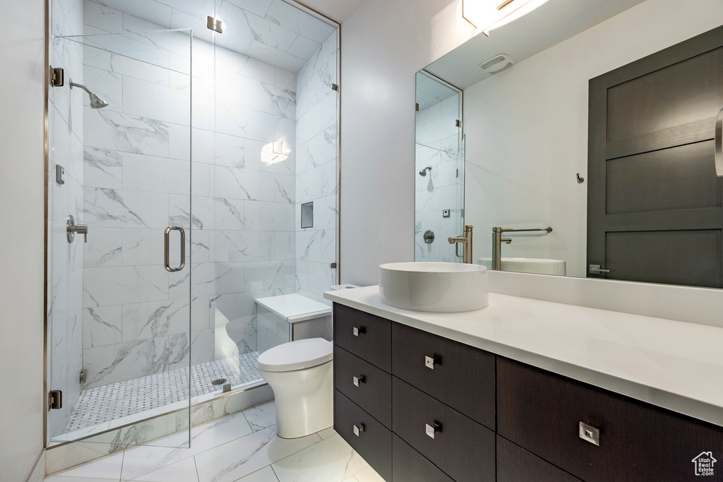 Bathroom with marble finish flooring, vanity, toilet, and a marble finish shower