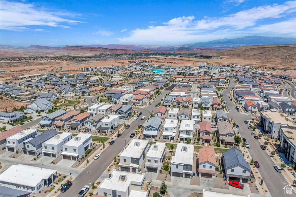Aerial view of property and surrounding area with a mountainous background and nearby suburban area