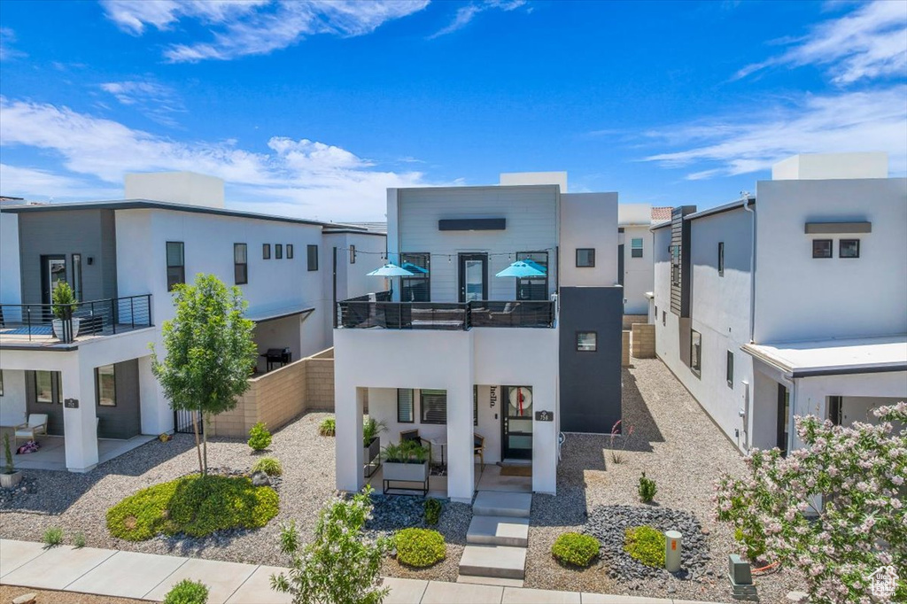 Contemporary house with a balcony, stucco siding, and a residential view