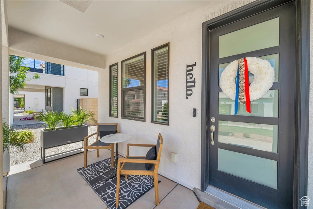 Doorway to property with stucco siding and covered porch