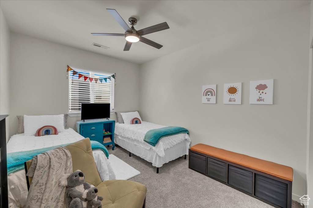 Carpeted bedroom with a ceiling fan