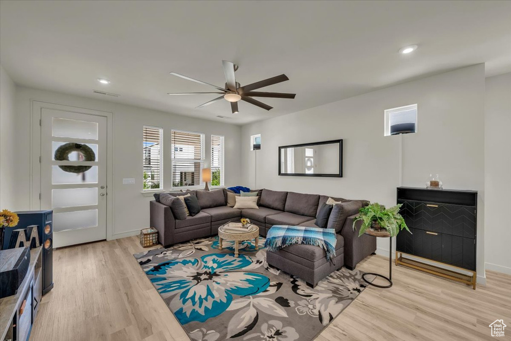 Living room with light wood-style flooring, a ceiling fan, recessed lighting, and baseboards