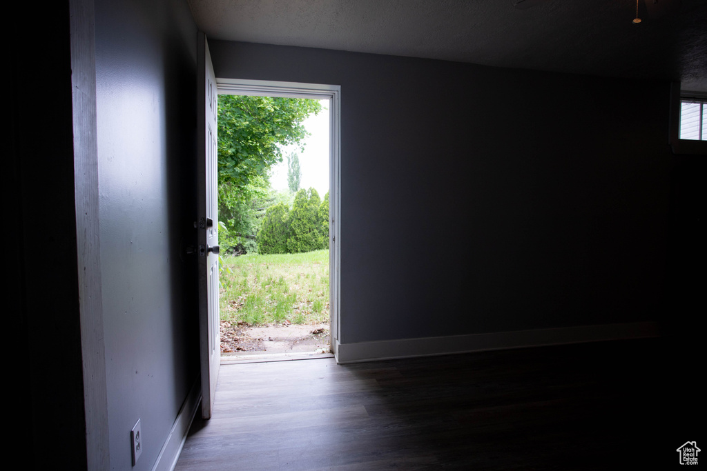 Doorway with wood finished floors and baseboards