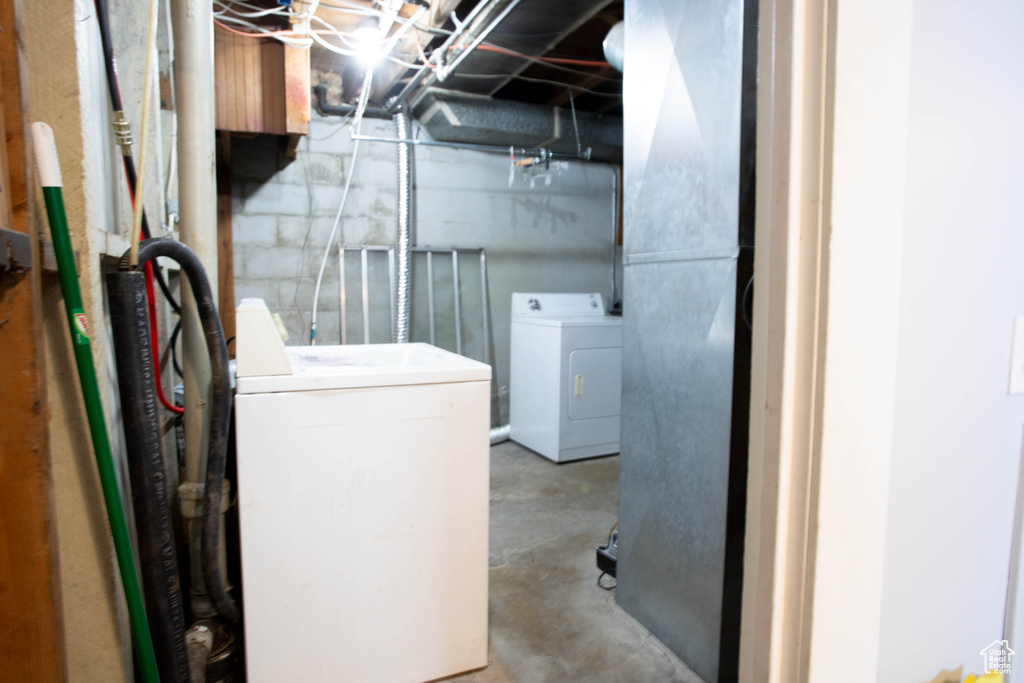 Unfinished basement featuring washing machine and clothes dryer