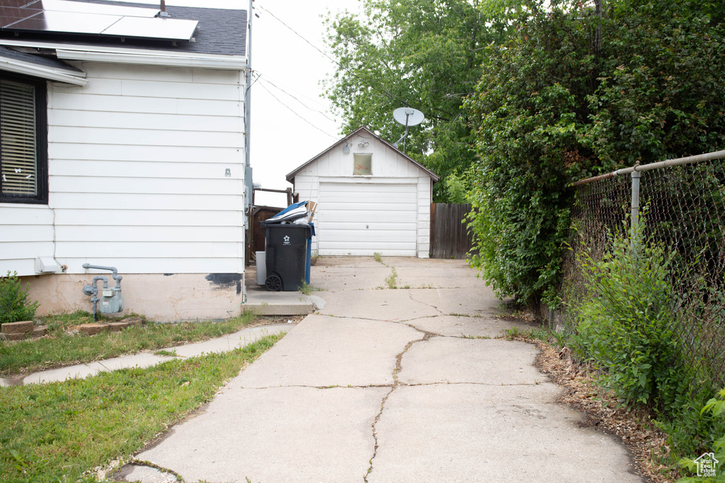 Detached garage featuring driveway and solar panels