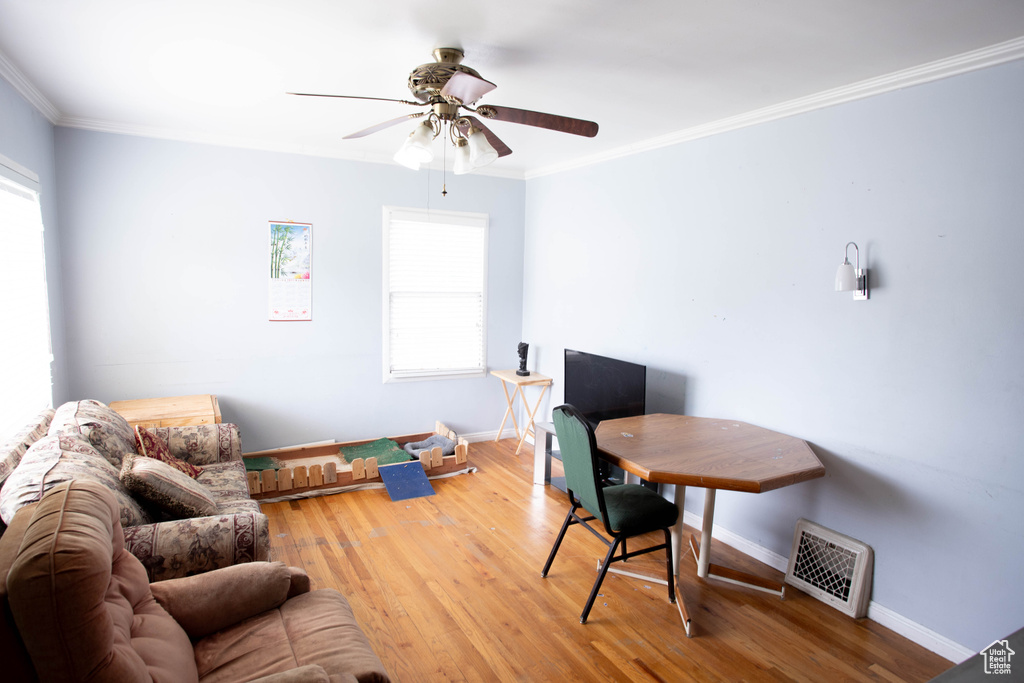Office featuring hardwood / wood-style flooring, a ceiling fan, baseboards, and crown molding