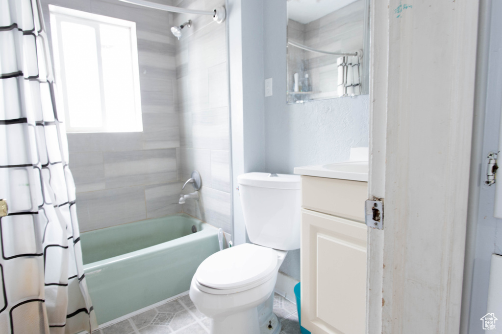 Bathroom with vanity, shower / bath combo, toilet, and tile patterned flooring