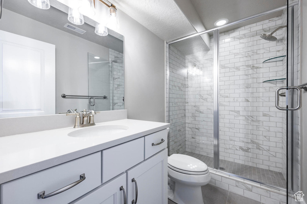 Full bathroom featuring vanity, a shower stall, and toilet