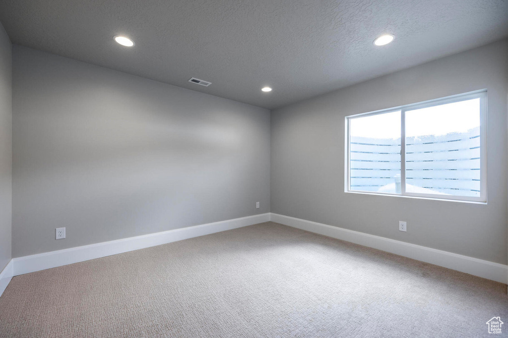 Carpeted empty room featuring recessed lighting, baseboards, and a textured ceiling