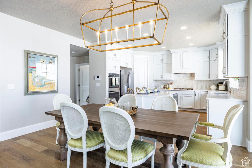 Dining space with baseboards, recessed lighting, a textured ceiling, and dark wood-type flooring