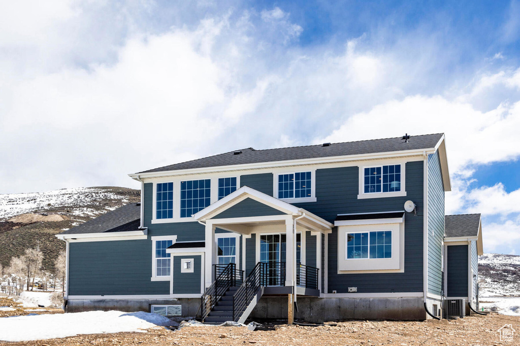 View of front of house with central AC unit and a mountain view