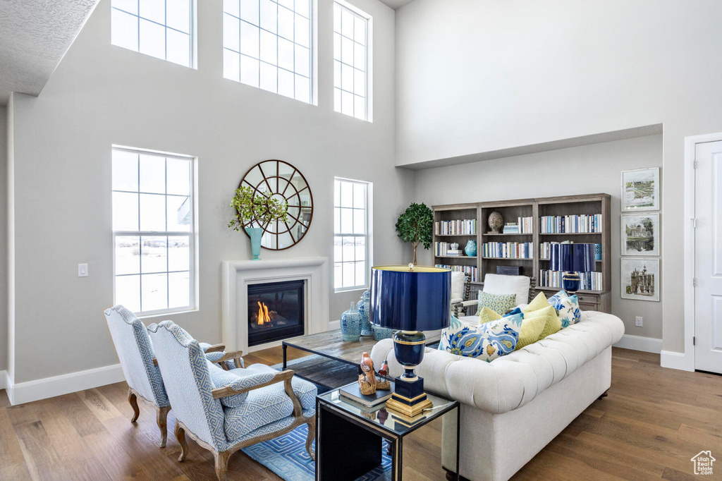 Living area featuring a towering ceiling, baseboards, and plenty of natural light