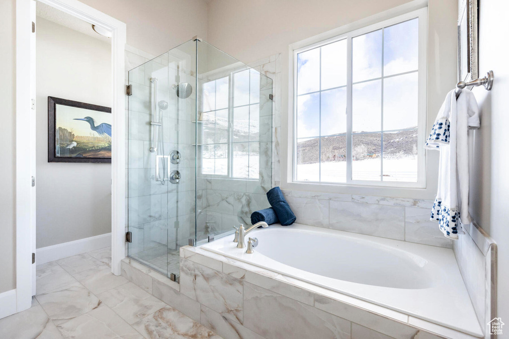 Full bathroom with a bath, a shower stall, marble finish flooring, and baseboards
