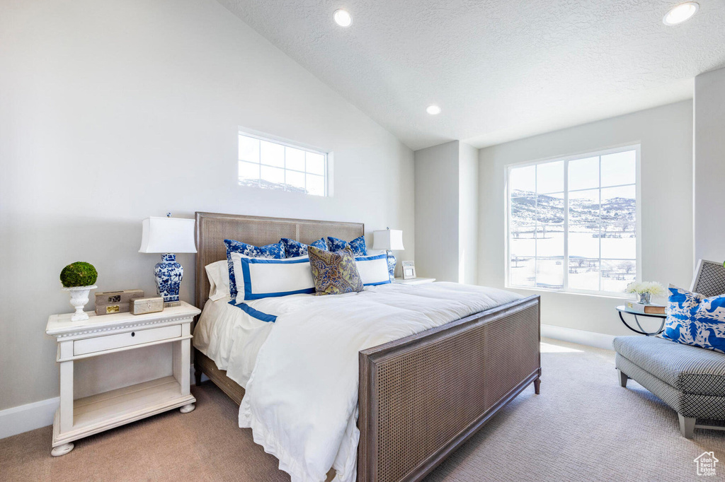 Carpeted bedroom featuring multiple windows, baseboards, vaulted ceiling, and recessed lighting